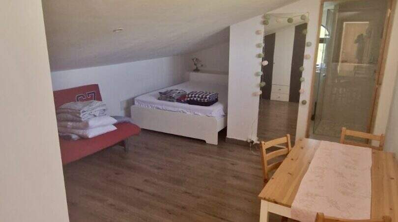 Dachgeschoss-Zimmer der Finca Inca mit Schräge, Holzboden, zwei Betten und Esstisch