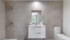 Baño moderno del apartamento de lujo en Palma con óptica de piedra natural gris, lavabo flotante y ducha a nivel del suelo.