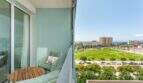 Balcón luminoso con muebles verde menta y vista al mar del apartamento exclusivo en Palma de Mallorca