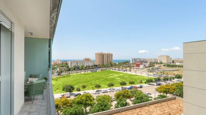 Balcón con vista al mar, áreas verdes y panorama urbano de un apartamento exclusivo en Palma de Mallorca