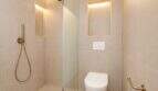 Modernes Badezimmer mit begehbarer Dusche, Wand-WC und goldenen Armaturen im Designer-Duplex Palma