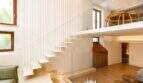 Modernes Duplex in Palma: Schwebende weiße Treppe mit Glasgeländer, Mezzanine-Ebene und Holzboden