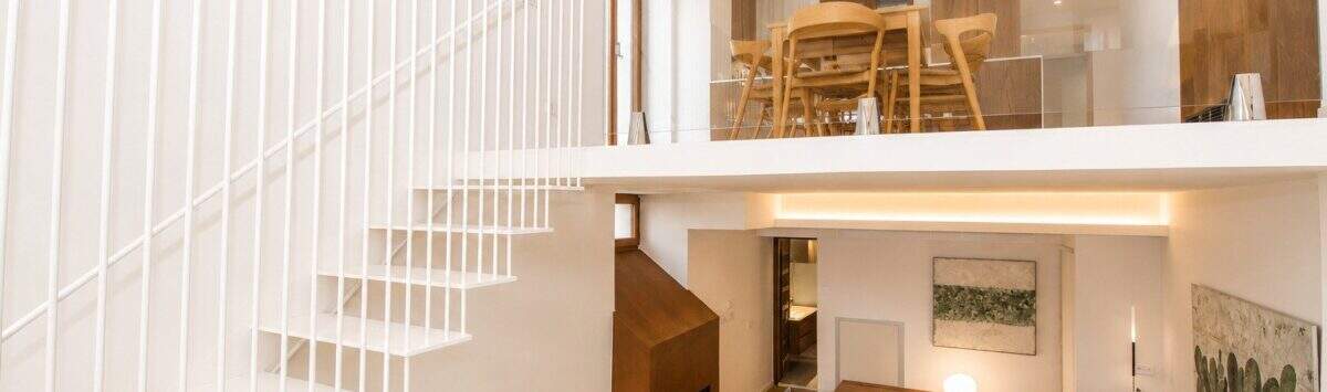 Offenes Duplex-Wohnzimmer mit weißer Designtreppe, Galerie, Kamin und hellem Holzboden in Palma
