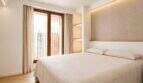 Helles Schlafzimmer mit Doppelbett, Polster-Kopfteil, LED-Beleuchtung und Balkonzugang im Designer-Duplex Palma