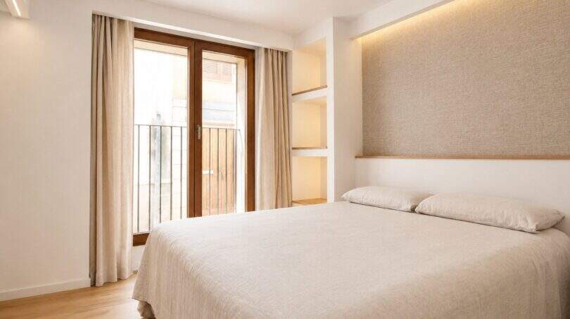 Helles Schlafzimmer mit Doppelbett, Polster-Kopfteil, LED-Beleuchtung und Balkonzugang im Designer-Duplex Palma