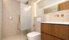 Modernes Designerbad mit Walk-in-Dusche, Wand-WC, Holzwaschtisch und goldenen Armaturen im Duplex Palma