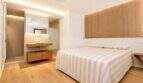 Helles Schlafzimmer mit Doppelbett, Holzboden und offenem Badezimmer mit Waschtisch im Designer-Duplex Palma