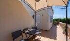 Überdachte Terrasse mit integriertem Schattenbereich und Zugang zum Nebengebäude