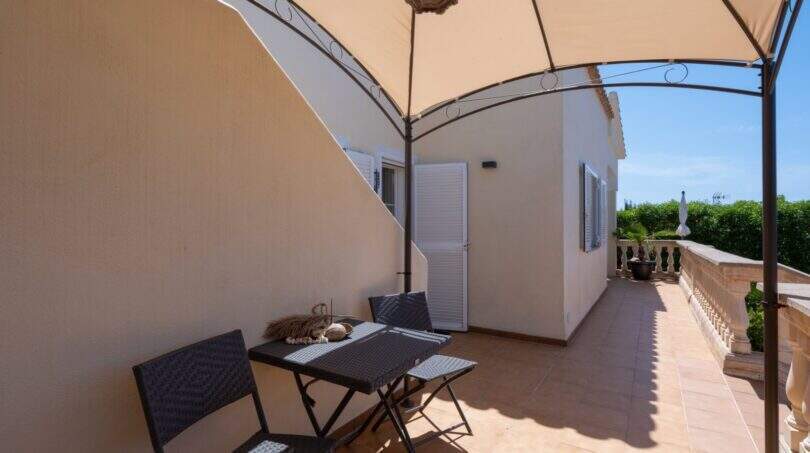 Überdachte Terrasse mit integriertem Schattenbereich und Zugang zum Nebengebäude
