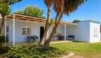 Weiße Finca-Außenansicht mit überdachter Terrasse, Palme und gepflegtem Garten in Palma de Mallorca