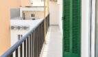 Estrecho balcón con persianas verdes, barandilla negra y vistas a la ciudad en el moderno ático El Arenal