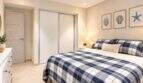 Luminoso dormitorio en el ático El Arenal con cama doble, armario empotrado y decoración de pared marina.