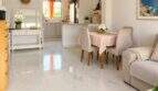Salón-comedor luminoso con piso de mármol, cocina abierta e interior moderno en el ático de Mallorca