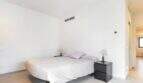 Helles Schlafzimmer mit Doppelbett, schwarzen Nachttischen und modernem Design im Stadthaus Artà.