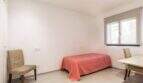 Helles Schlafzimmer mit Einzelbett, zwei Stühlen und Fenster im Stadthaus in Artà