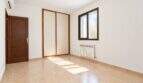 Leeres Schlafzimmer mit Fliesenboden, Einbauschrank, Fenster und Heizkörper im Wohnhaus in Establiments