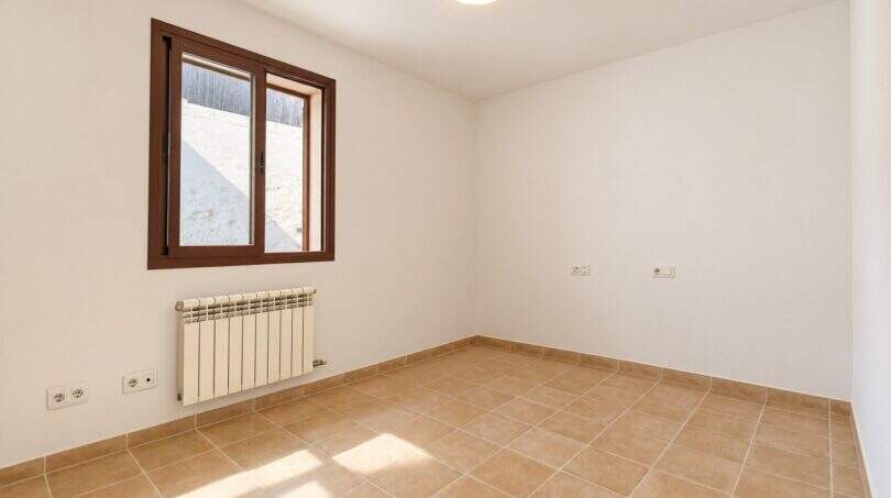 Leeres Zimmer mit Bodenfliesen, Heizkörper und Fenster mit Blick auf die Tramuntana, Wohnhaus Establiments