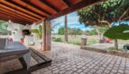 Terraza cubierta con adoquines, zona de barbacoa y vistas al jardín de la finca cerca de Inca