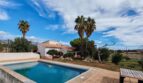 Finca Inca: Piscina exterior con azulejos de terracota, villa blanca, palmeras y vistas de la sierra de Tramuntana bajo cielo azul