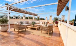 Terraza soleada con muebles lounge, pérgola, baldosas de terracota y vistas al mar en La Bonanova, Palma