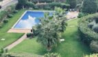 Piscina comunitaria con jardín cuidado y palmeras de la comunidad La Bonanova, Palma de Mallorca