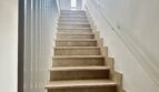 Luminosa escalera con tramo de mármol y barandilla de vidrio en amplio apartamento en La Bonanova, Palma