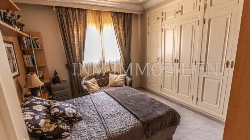 Elegantes Schlafzimmer der Villa in Marratxí mit eingebautem Kleiderschrank, Doppelbett und stilvollen Vorhängen.