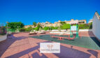 Gemeinschaftsbereich der Wohnanlage in Cales de Mallorca mit Kinderspielplatz, Sitzbänken und gepflegten Grünanlagen.