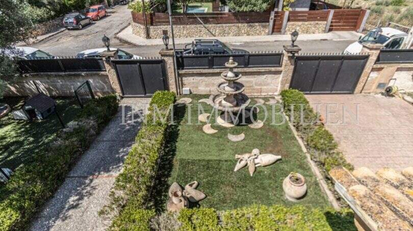 Gepflegter Eingangsbereich der Villa in Marratxí mit Springbrunnen, Skulpturen und elegantem Einfahrtstor.