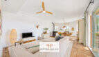 Helles Wohnzimmer mit Deckenventilator, Kaminofen, Essbereich und Terrassenzugang im Haus Cala Murada