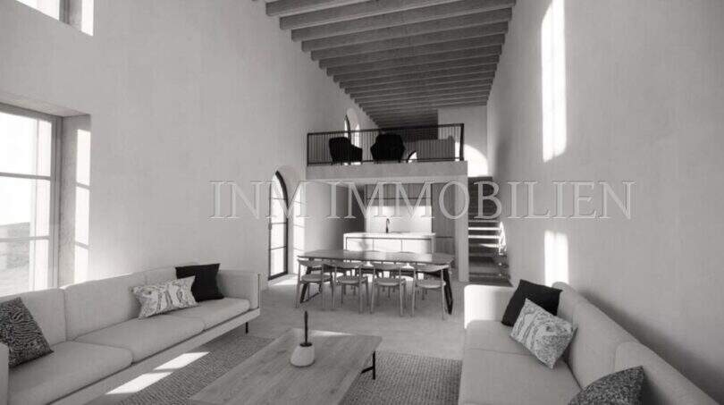 Sala de estar luminosa con galería, techo de vigas de madera y zona de comedor abierta – finca rústica en Sóller