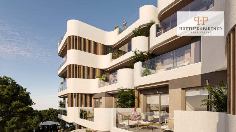Moderne Neubauwohnanlage in Cala Ratjada mit geschwungenen Balkonen, Glasbrüstungen und üppiger Begrünung