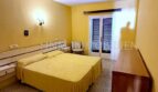 Helles Schlafzimmer mit Doppelbett, gelbem Wandanstrich und Balkonzugang in Meerlinie-Wohnung El Arenal