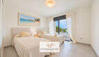 Helles Schlafzimmer im Penthouse Colonia de Sant Jordi mit zwei Betten und Meerblick durch Panoramafenster
