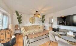 Bright living room with Chesterfield sofa, wooden floor and modern TV in renovated apartment at Playa de Palma