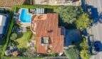 Vista aérea villa mediterránea Alcanada con techo de terracota, piscina, jardín y acceso cerca de Alcúdia