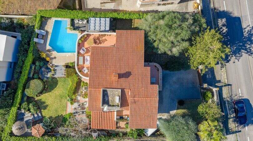Vista aérea villa mediterránea Alcanada con techo de terracota, piscina, jardín y acceso cerca de Alcúdia