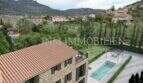 Vista aérea finca rústica de piedra natural en Sóller con piscina, jardín y panorama montañoso de la Tramuntana