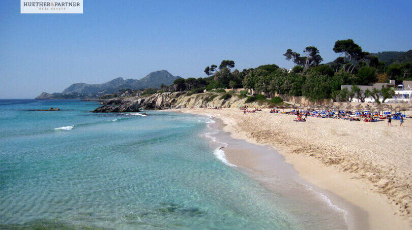 Türkisblaues Meer und feiner Sandstrand in Cala Ratjada, nahe der Neubauwohnung mit Balkon und Stellplatz.