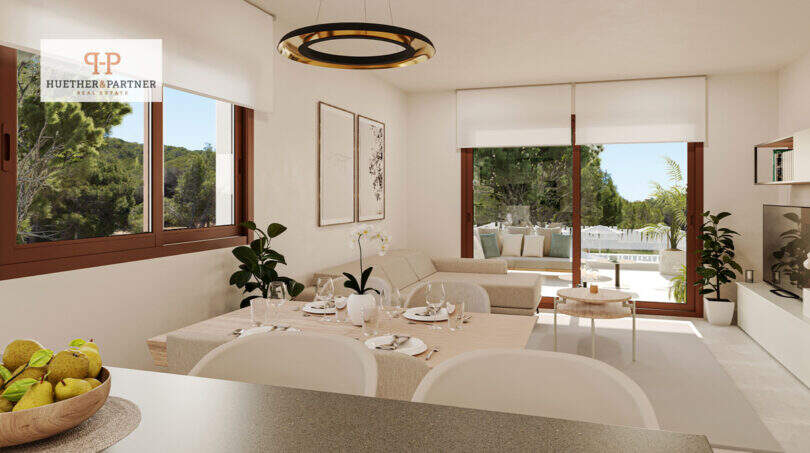 Helles Wohn-Esszimmer mit Balkonzugang, modernem Rundleuchter und Blick ins Grüne in Cala Ratjada