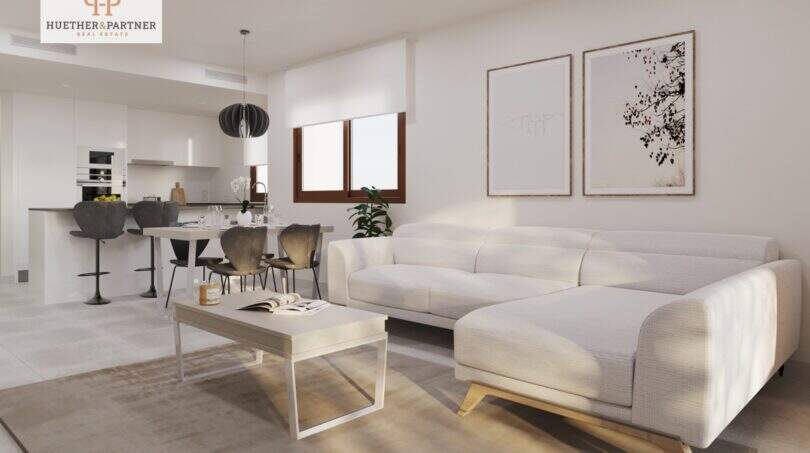 Heller Wohnbereich mit weißem Sofa und offener Küche in strandnaher Neubauwohnung in Cala Ratjada