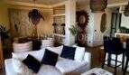 Helles Wohnzimmer mit weißem Sofa, dunklen Akzentkissen und stilvollen Rattanlampen im Penthouse Playa de Palma
