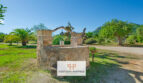 Fuente de piedra rústica en la finca de Felanitx con jardín verde y vistas a la montaña en Sant Salvador