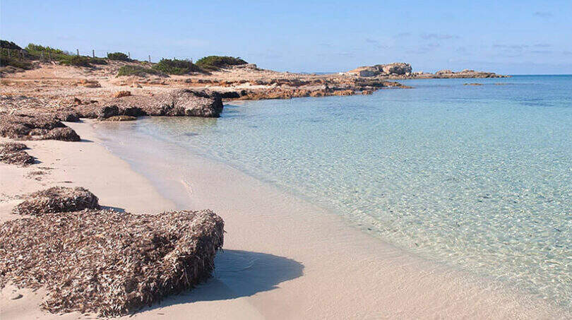 Türkisfarbenes Meer und weißer Sandstrand nahe Colonia de Sant Jordi, Blick auf die felsige Küstenlandschaft