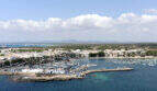 Luftaufnahme des Hafens von Colonia de Sant Jordi mit Booten, türkisblauem Meer und Ortschaft