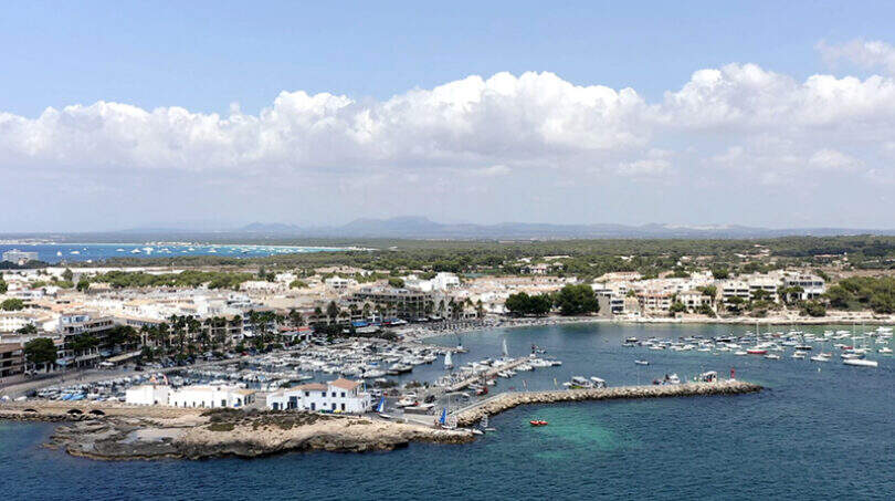 Luftaufnahme des Hafens von Colonia de Sant Jordi mit Booten, türkisblauem Meer und Ortschaft