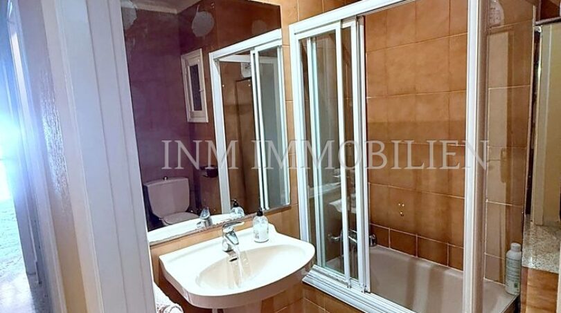 Badezimmer mit Standwaschbecken, Badewanne mit Glasabtrennung und orangefarbenen Fliesen in Strandwohnung El Arenal
