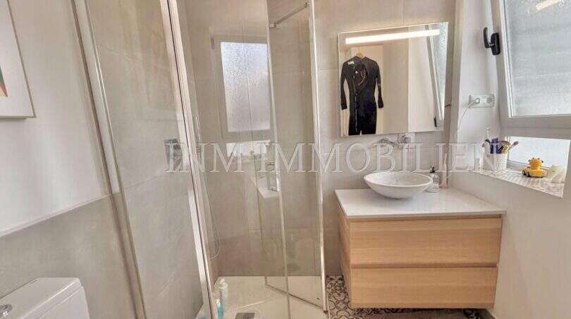Modernes Badezimmer mit Glasdusche, Regendusche, Holzwaschtisch und Mosaikfliesen in Maisonette-Wohnung Palma