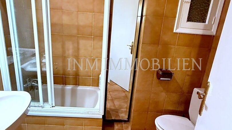 Badezimmer mit Badewanne, Glasabtrennung, WC und orangefarbenen Fliesen in Meereslinie-Wohnung El Arenal
