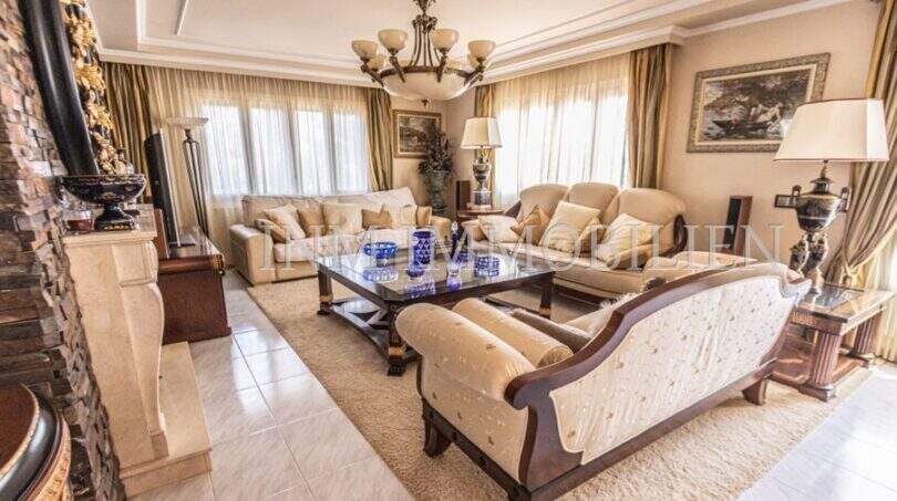 Elegantes Wohnzimmer der Villa in Marratxí mit klassischen Sofas, Marmorkamin und Kronleuchter